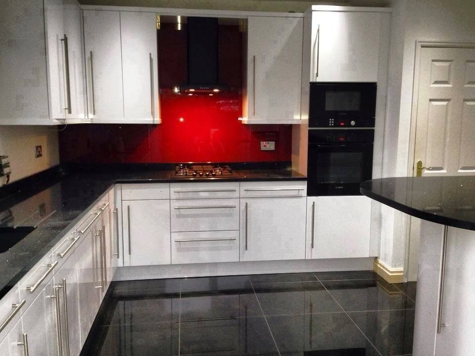 Gloss white kitchen with red glass splashback