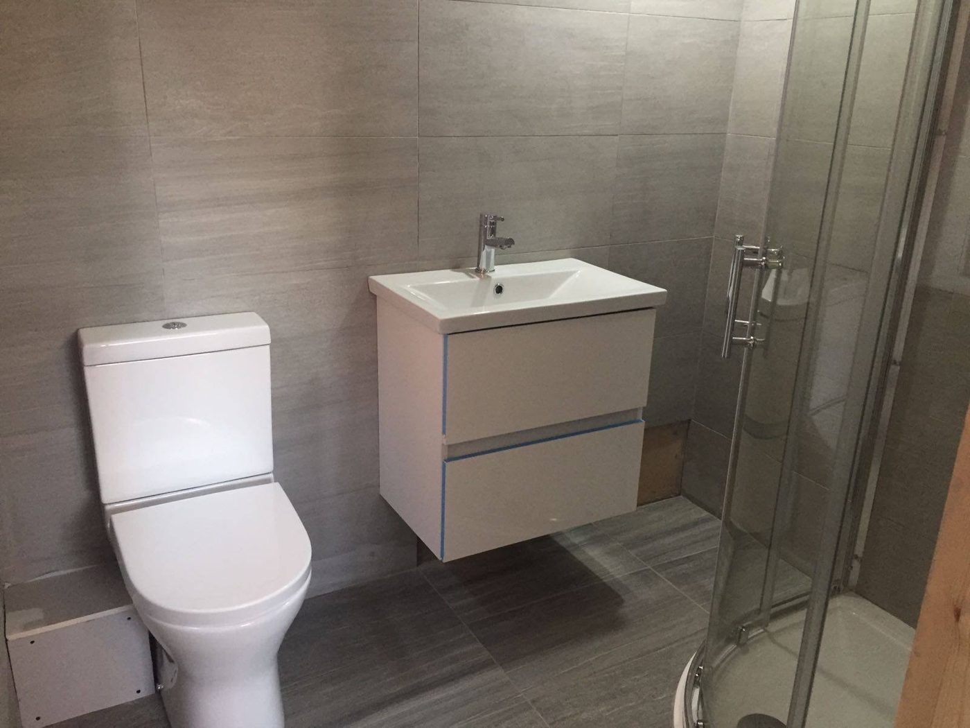 Shower room with wall-hung vanity unit, WC and floor-to-ceiling tiles